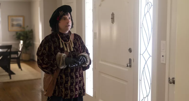 David Krumholtz as Bernard the Elf standing near a front door and looking concerned in The Santa Clauses