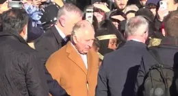 King Charles is held by a security guard after an egg was apparently thrown by someone in the crowd