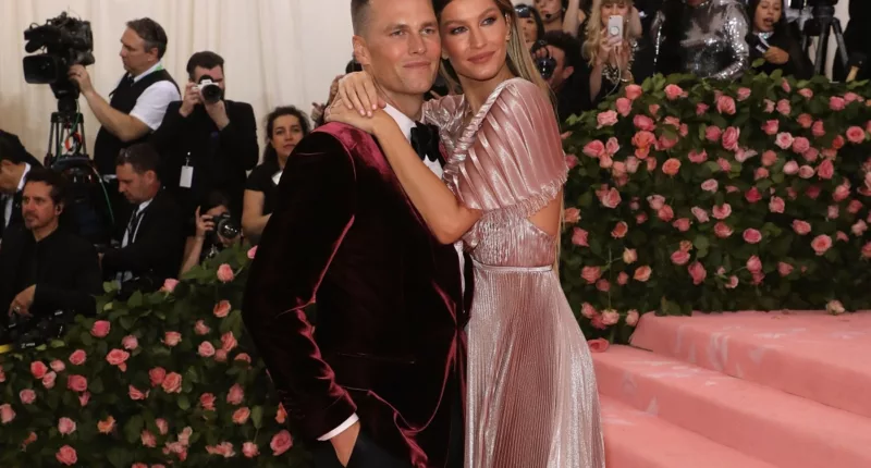 Tom Brady and Gisele Bundchen stand together at an event.