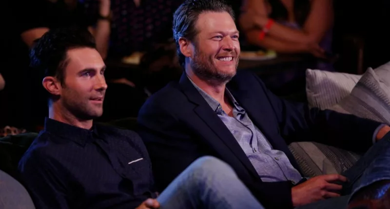 Adam Levine and Blake Shelton sit together side by side
