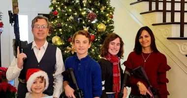 Representative Andy Ogles (left) is pictured with his wife Monica and their three kids - holding what looked like assault rifles as they posed for a Christmas card in 2021