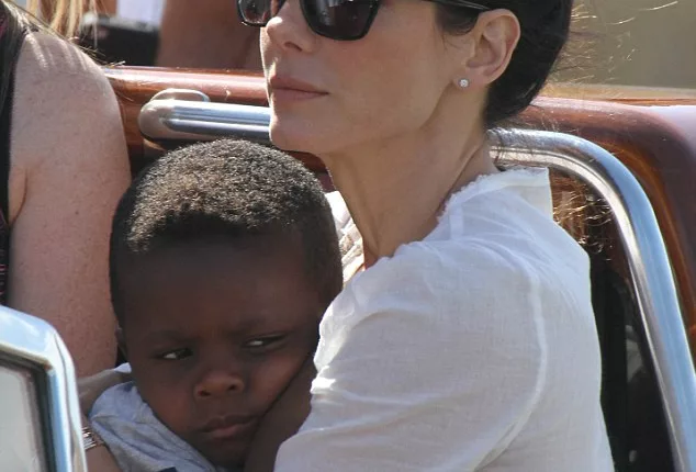 Mommy's boy: Sandra Bullock and her son Louis get a water taxi to their Venice hotel on Tuesday