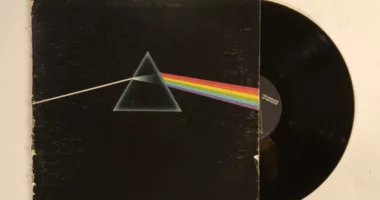 A drawing of a pyramid prism refracting a white beam of light into a rainbow on the album cover for Pink Floyd