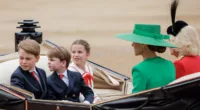 Prince George, Prince Louis, and Princess Charlotte looking back while riding in a carriage with Kate Middleton and Camilla Parker Bowles