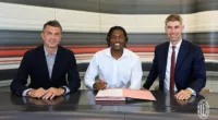 Rafael Leao (middle) puts pen to paper on his new deal alongside AC Milan technical director, Paolo Maldini (left) and Sporting Director, Frederic Massara (right)