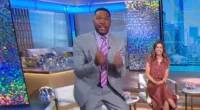 GMA's Michael Strahan springs out of his seat and screams 'make the shot!' at co-host Will Reeve on live TV