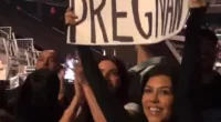 Surprise! Kourtney lifted a sign which read 'Travis, I'm pregnant!' while in the crowd, Kourtney made a clear reference the band's iconic All The Small Things music video,