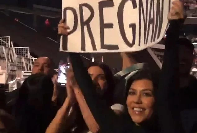 Surprise! Kourtney lifted a sign which read 'Travis, I'm pregnant!' while in the crowd, Kourtney made a clear reference the band's iconic All The Small Things music video,