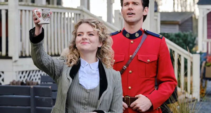Faith (Andrea Brooks), waving, standing in front of Nathan (Kevin McGarry) in a mountie uniform in 'When Calls the Heart' Season 9