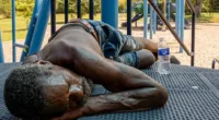A person rests in the shade on a playground set in the Hungry Hill neighborhood, Texas, amid the heat on Tuesday