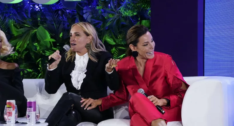 Sonja Morgan holds a microphone and sits next to Luann de Lesseps