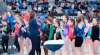 The little girl excitedly shuffles forward as she anticipates being handed the medal, before the official moves on to the next gymnast in the lineup