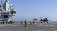 The 920-ft long HMS Queen Elizabeth has the capacity to accommodate 36 stealth jets and to carry 24 such aircraft on operations. Pictured: Aircraft handler at work as F-35B's carry out flight operations