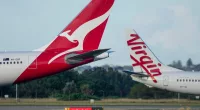 Qantas and Virgin Australia planes on the tarmac at an airport.
