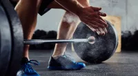 man getting ready to lift heavy dumbbell at the gym