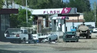 Broken and smashed cars lie close to a petrol station in the hastily abandoned city