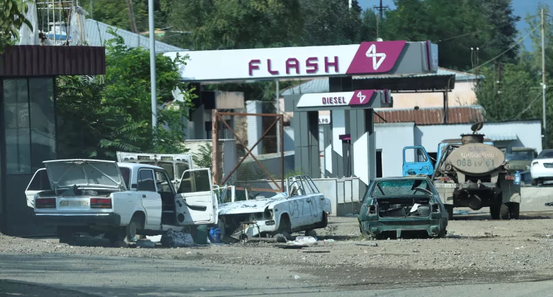 Broken and smashed cars lie close to a petrol station in the hastily abandoned city
