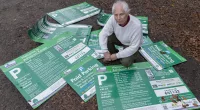 Landscape Recovery Manager Mark Infield with signs that have been ripped off an thrown into bushes