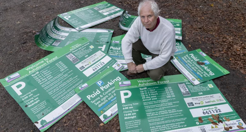 Landscape Recovery Manager Mark Infield with signs that have been ripped off an thrown into bushes