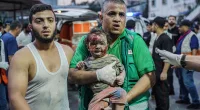 A paramedic holds a girl after bombing in Gaza