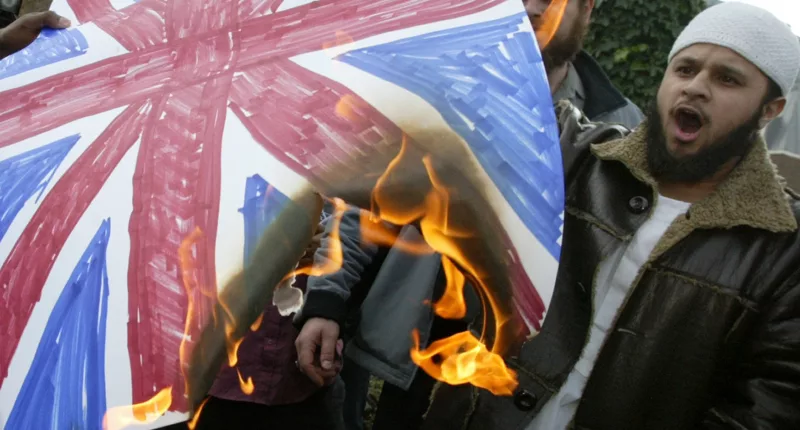 Members of the Islamic extremist group Al Muhajiroun burn a Union Jack flag outside the London Central Mosque in Regents Park