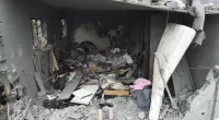 A Palestinian goes through his belongings after an Israeli attack in Gaza on Sunday