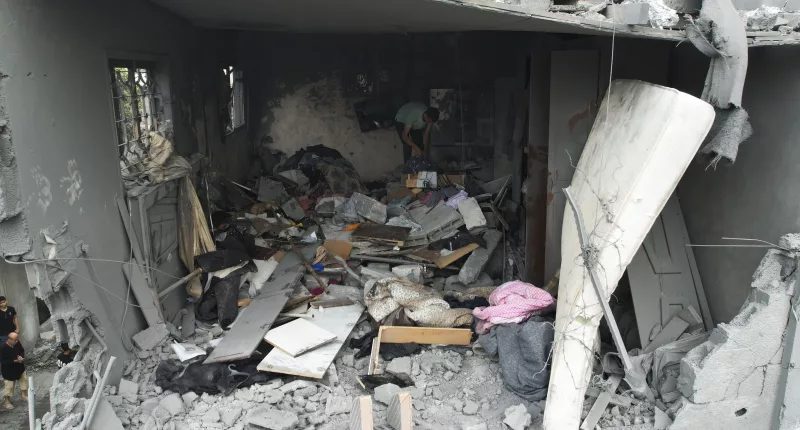 A Palestinian goes through his belongings after an Israeli attack in Gaza on Sunday