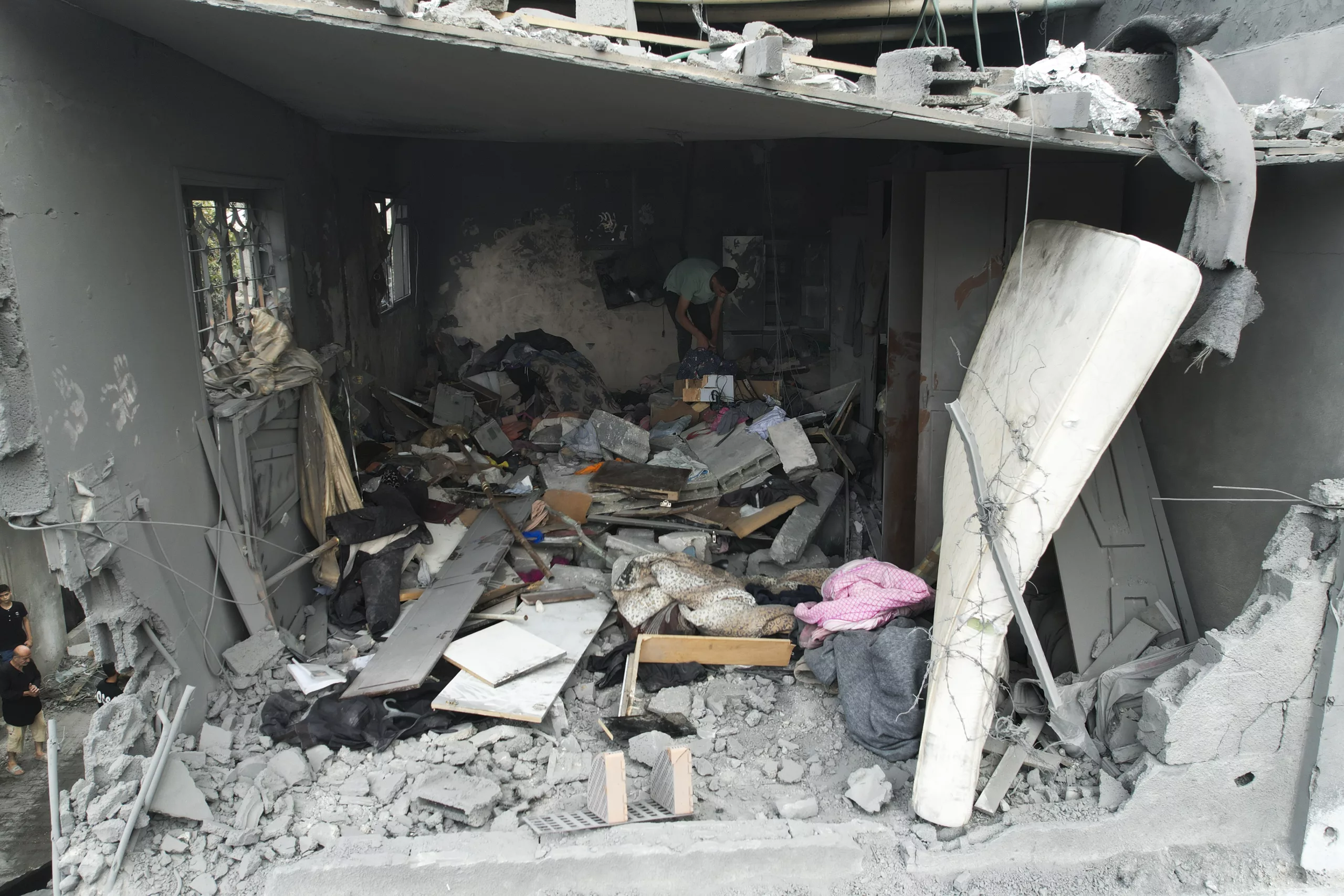 A Palestinian goes through his belongings after an Israeli attack in Gaza on Sunday