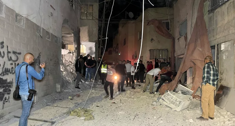 People inspect the damage after an Israeli strike hit a compound beneath a mosque in the occupied West Bank