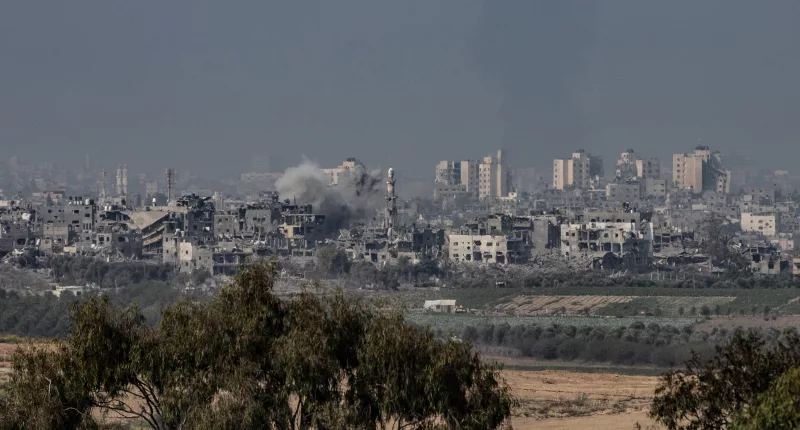 Smoke rises amid destroyed buildings in Gaza seen from Sderot