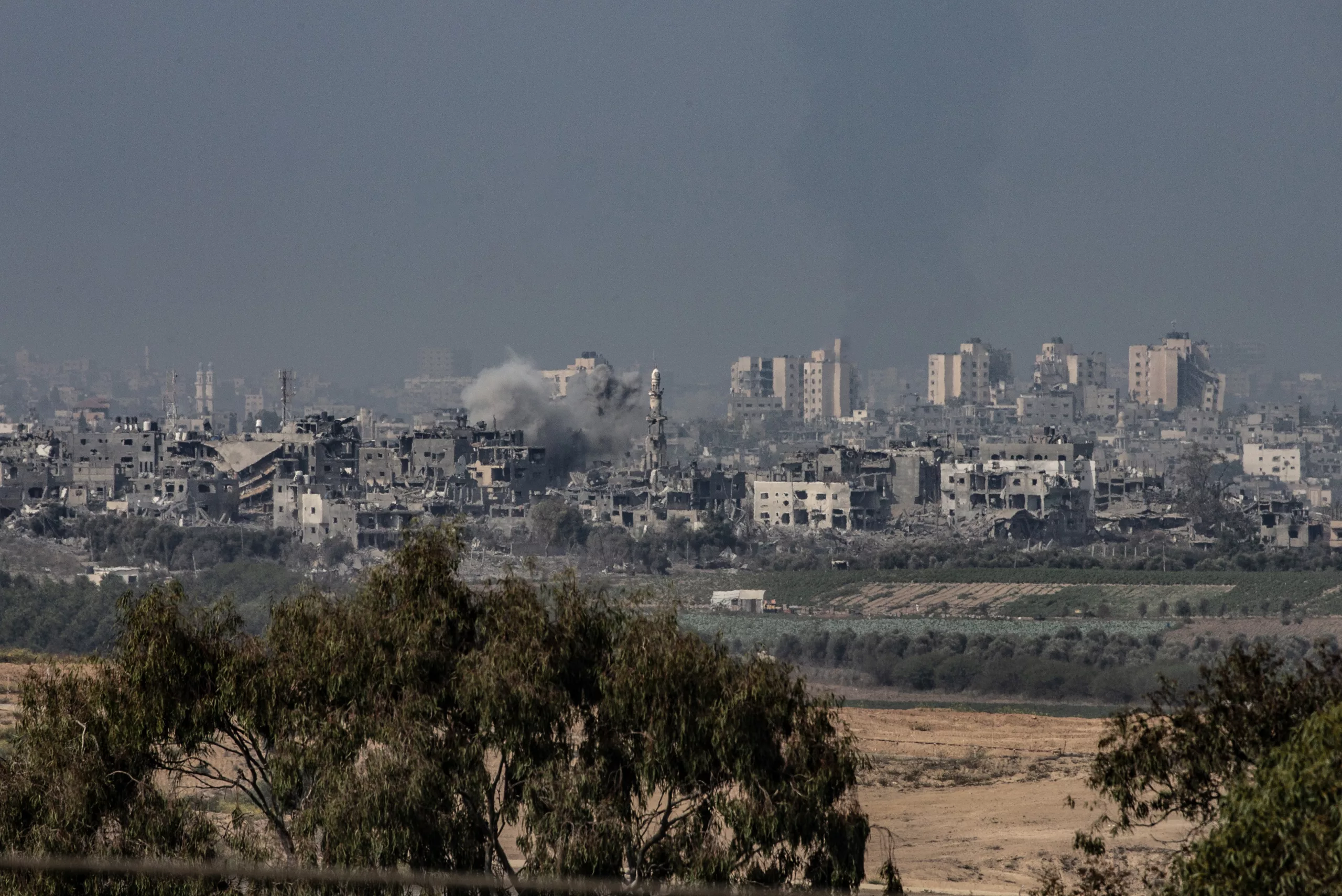 Smoke rises amid destroyed buildings in Gaza seen from Sderot