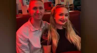 Aaron Pennington and Breanne Pennington smile together in a booth.