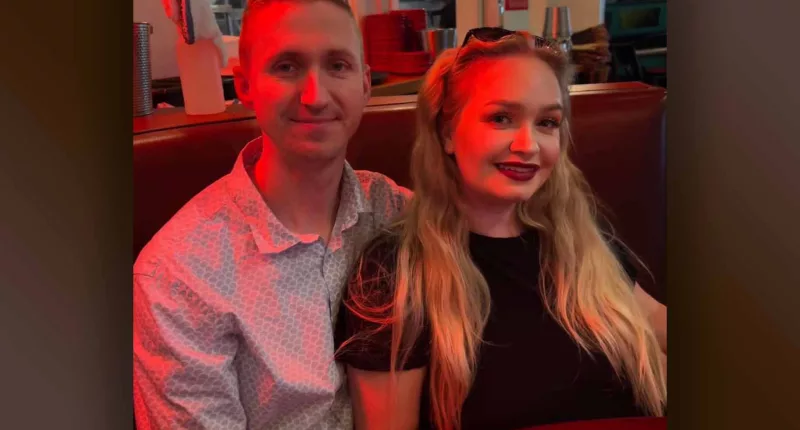 Aaron Pennington and Breanne Pennington smile together in a booth.