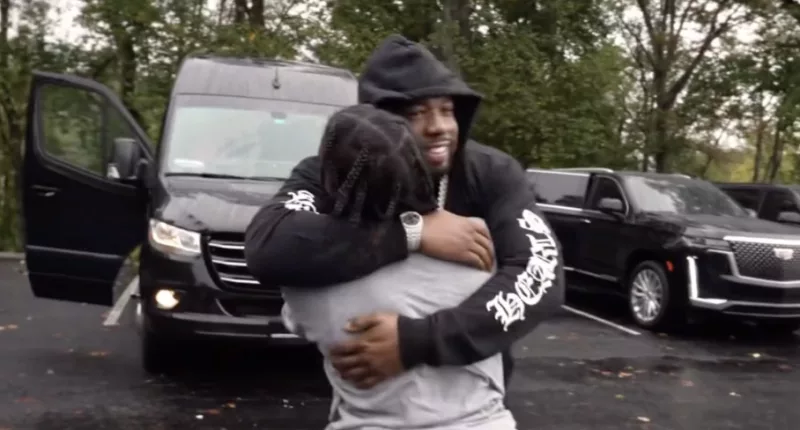 Rapper 42 Dugg (pictured with his back to the camera) was embraced by loved ones immediately after he was released from an Atlanta prison on Monday