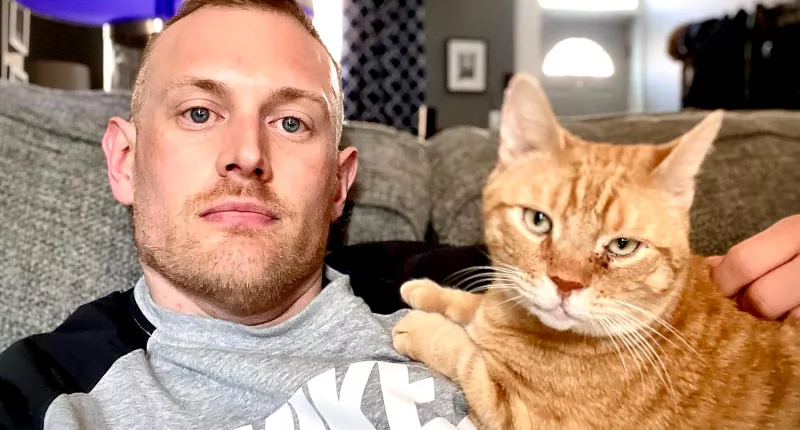 Josh Kruger pictured with his cat on social media