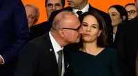 Croatian minister tries to kiss German counterpart in group photo