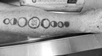 Colorado officials are searching to identify a woman by her three unique tattoos, including this tattoo of the moon's different phases with the number 18 in the center