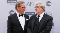 George Lucas and Steven Spielberg posing in suits at the 2016 American Film Institute Life Achievement Awards.