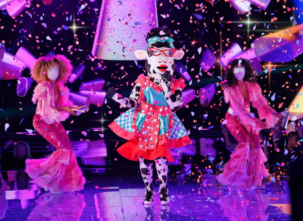 Cow performing on stage with backup dancers in