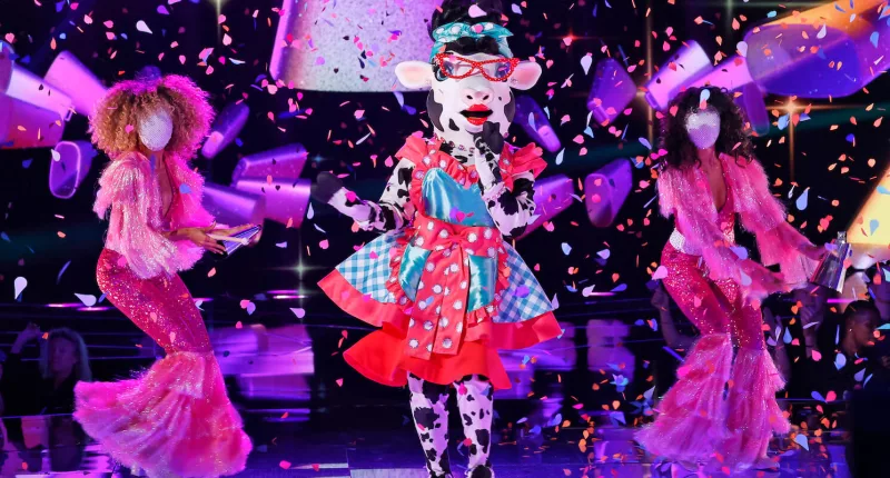 Cow performing on stage with backup dancers in