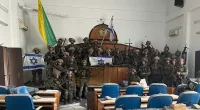 Israeli troops pose with guns in Gaza's parliament building