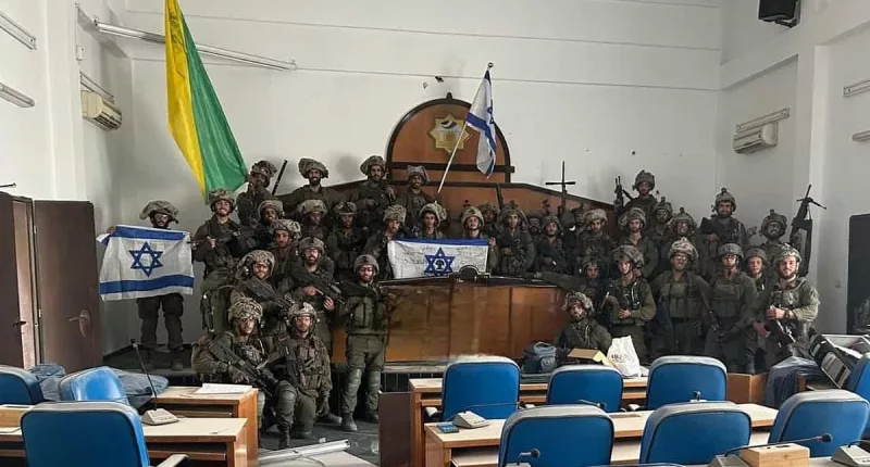 Israeli troops pose with guns in Gaza's parliament building