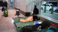 Migrants move into Boston's AIRPORT as city runs out of beds for them