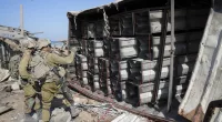 Israeli soldiers prepare explosives to blow up a Hamas arms dump on a beach in Gaza