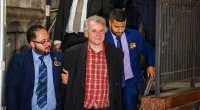 Obama's ex-National Security Council advisor SMILES during perp walk