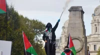 A pro-Palestine protester sets off fireworks near The Cenotaph in London at an earlier march