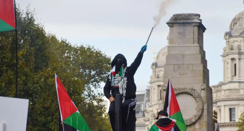 A pro-Palestine protester sets off fireworks near The Cenotaph in London at an earlier march