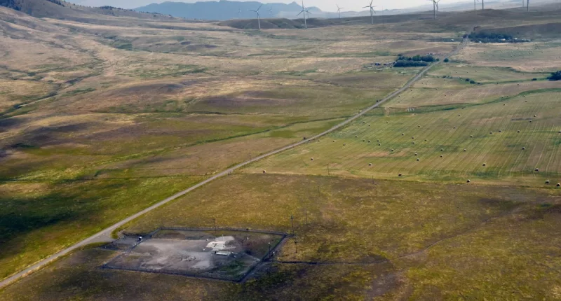 In this image provided by the U.S. Air Force, wind turbines spin near the Malmstrom Air Force Base missile launch site Alpha-03 in Geyser, Mont., in August 2023. As the nation