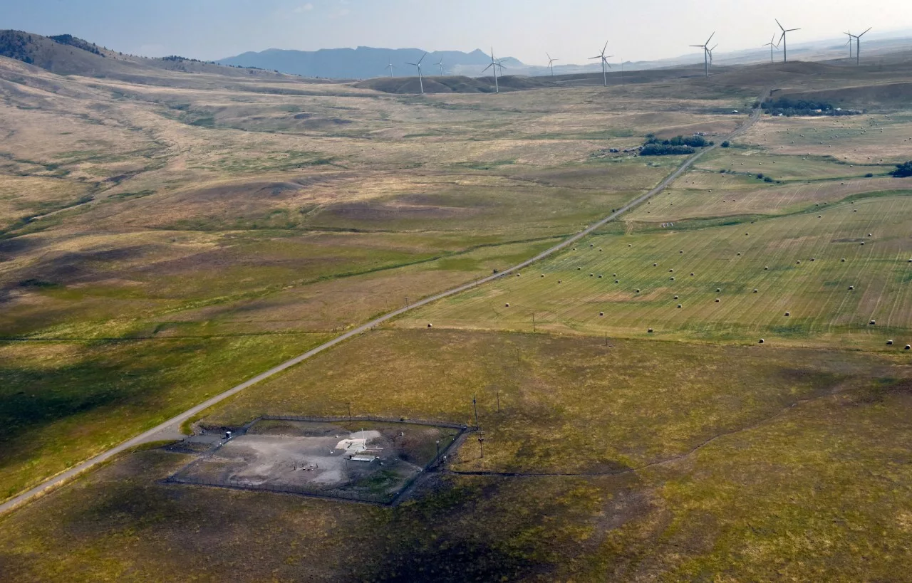 In this image provided by the U.S. Air Force, wind turbines spin near the Malmstrom Air Force Base missile launch site Alpha-03 in Geyser, Mont., in August 2023. As the nation