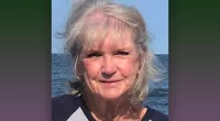 Claudia Voight smiles with a body of water behind her.